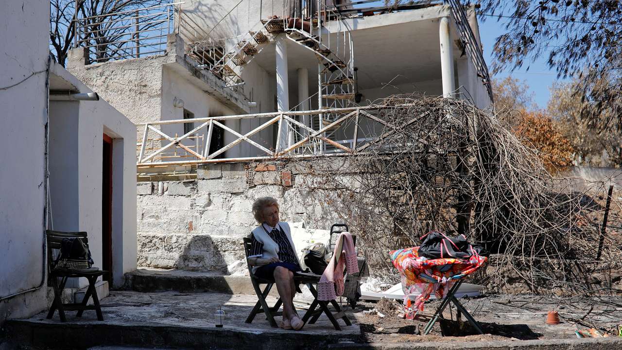 FILE PHOTO: Eleni Anagnostaki sits in the yard of her destroyed house in the village of Mati, near Athens