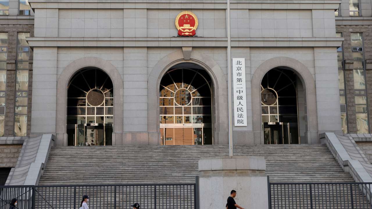 FILE PHOTO: People walk past one of the entrances of Beijing No. 2 Intermediate People's Court where Australian writer Yang Hengjun is expected to face trial on espionage charges, in Beijing