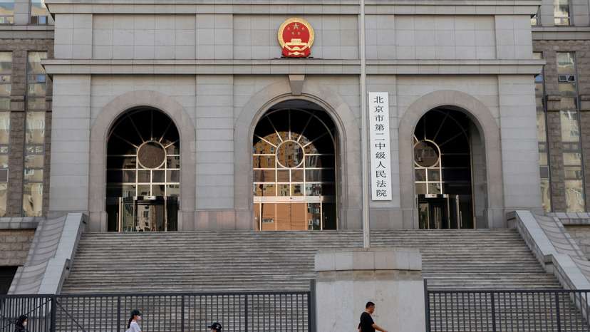 FILE PHOTO: People walk past one of the entrances of Beijing No. 2 Intermediate People's Court where Australian writer Yang Hengjun is expected to face trial on espionage charges, in Beijing