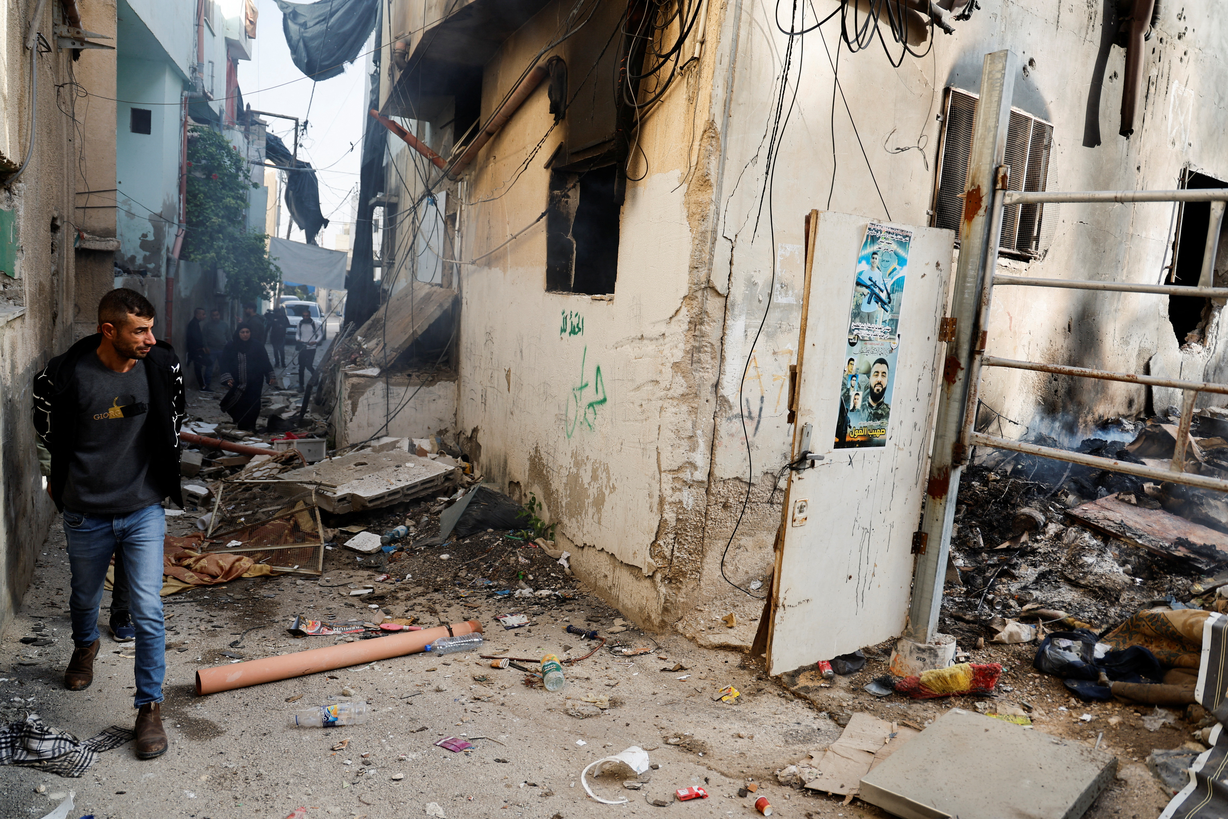 Palestinians check the damage in a street in the aftermath of an Israeli raid in Jenin