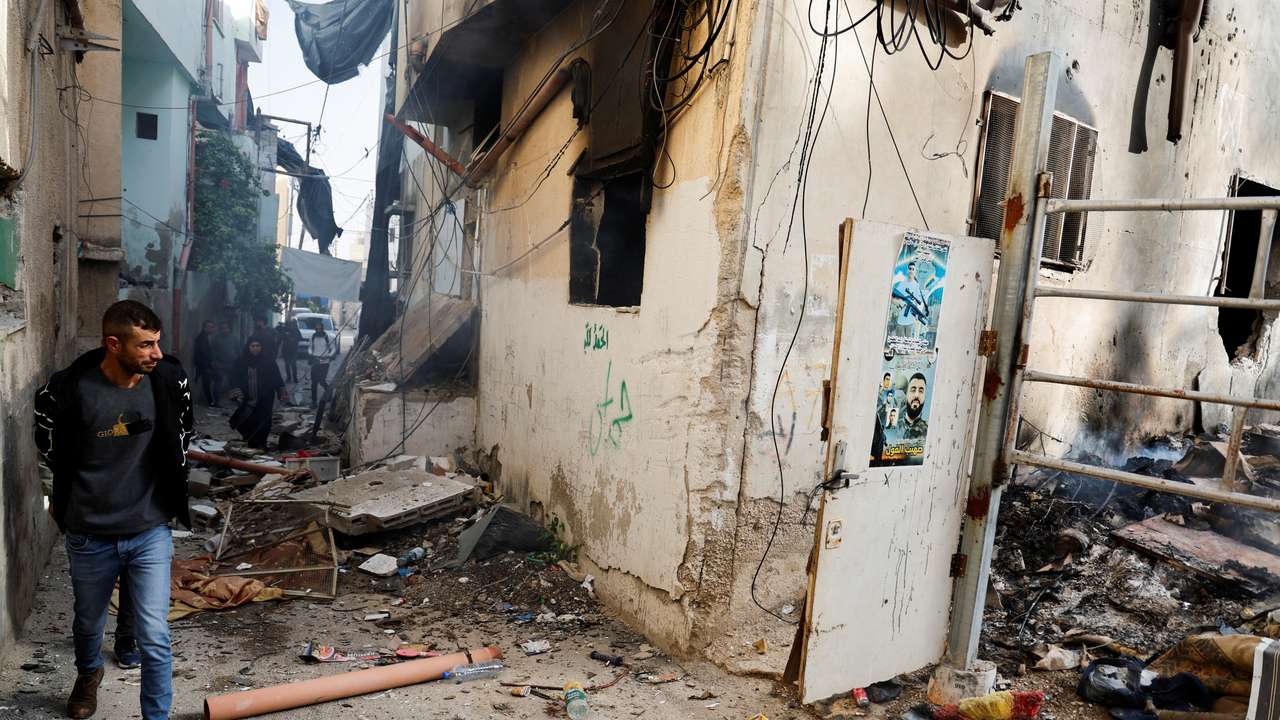Palestinians check the damage in a street in the aftermath of an Israeli raid in Jenin