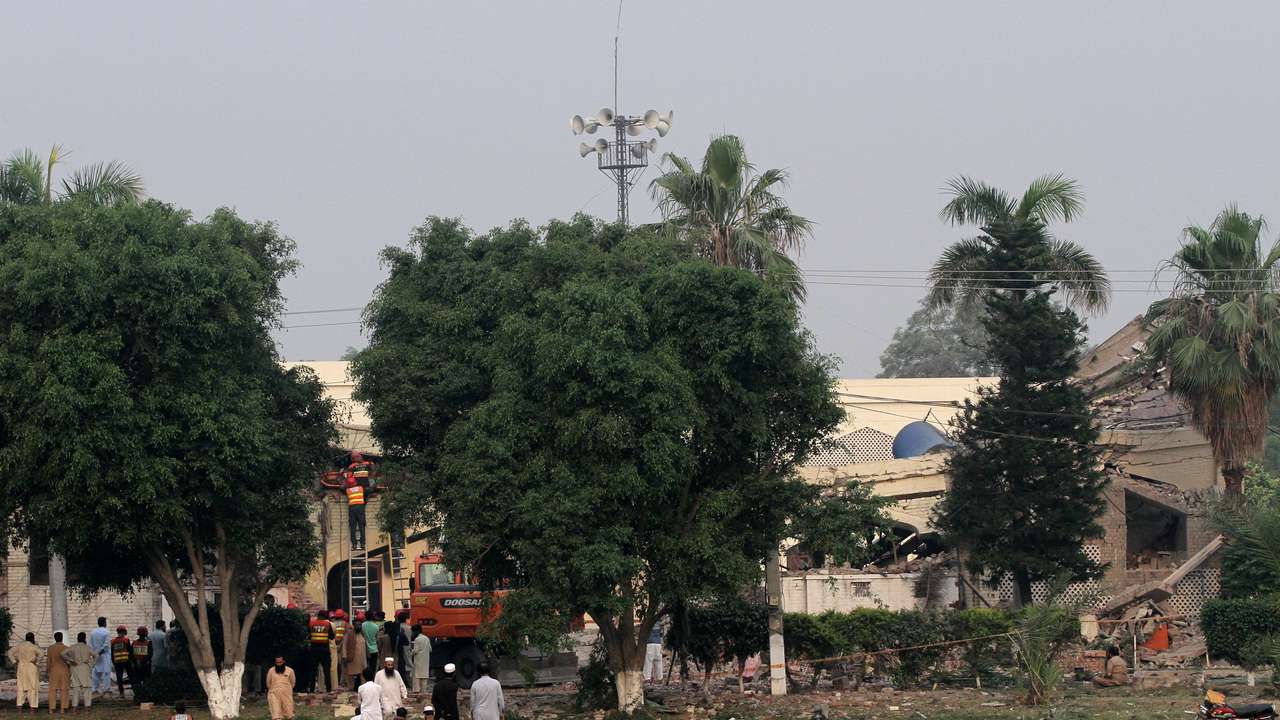Rescuers search for survivors in a damaged building after it was hit by an Indian strike in Muridke