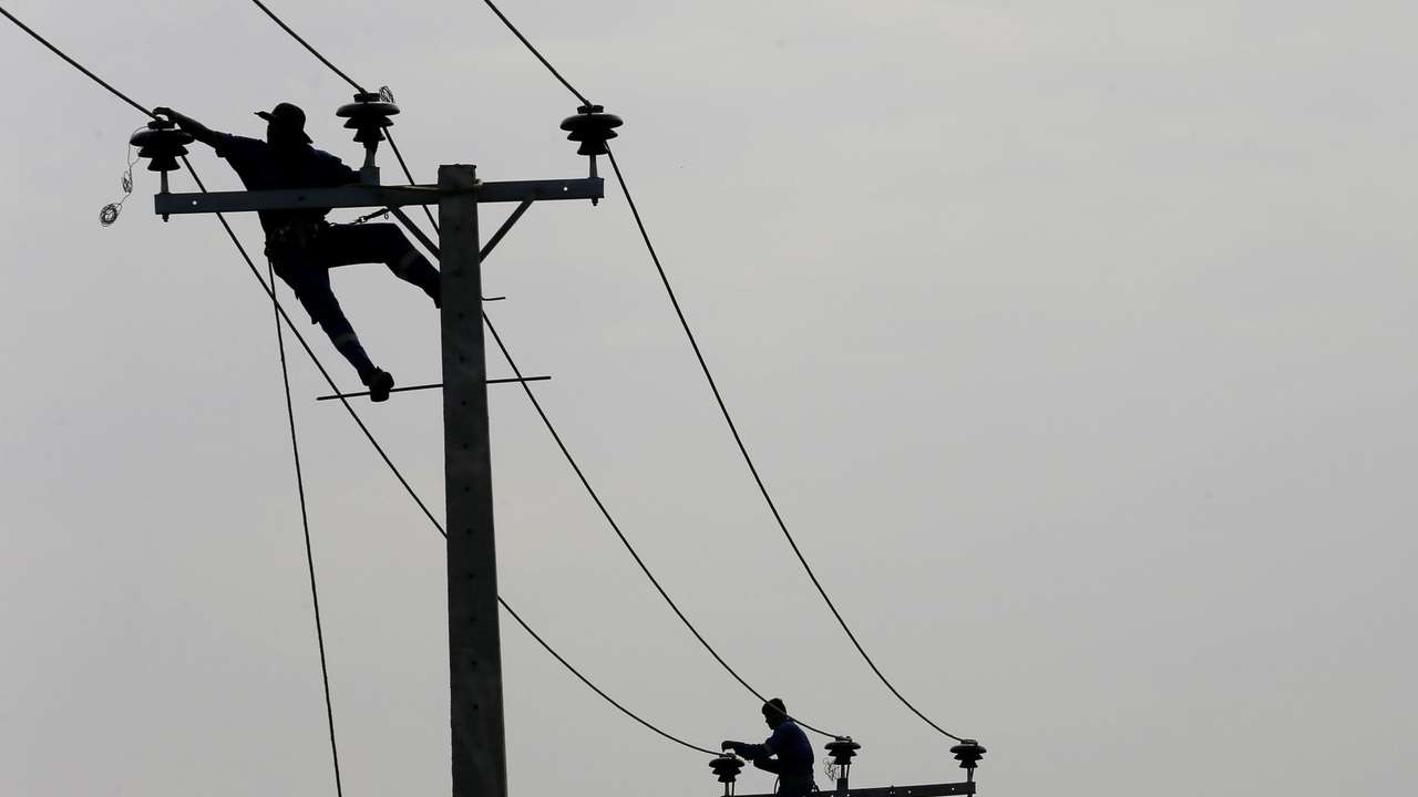 Employees from eletricity board pull electric cables on top of electricity posts in Piliyandala, Sri Lanka