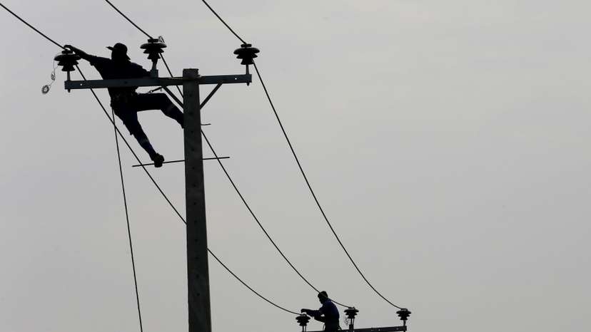 Employees from eletricity board pull electric cables on top of electricity posts in Piliyandala, Sri Lanka