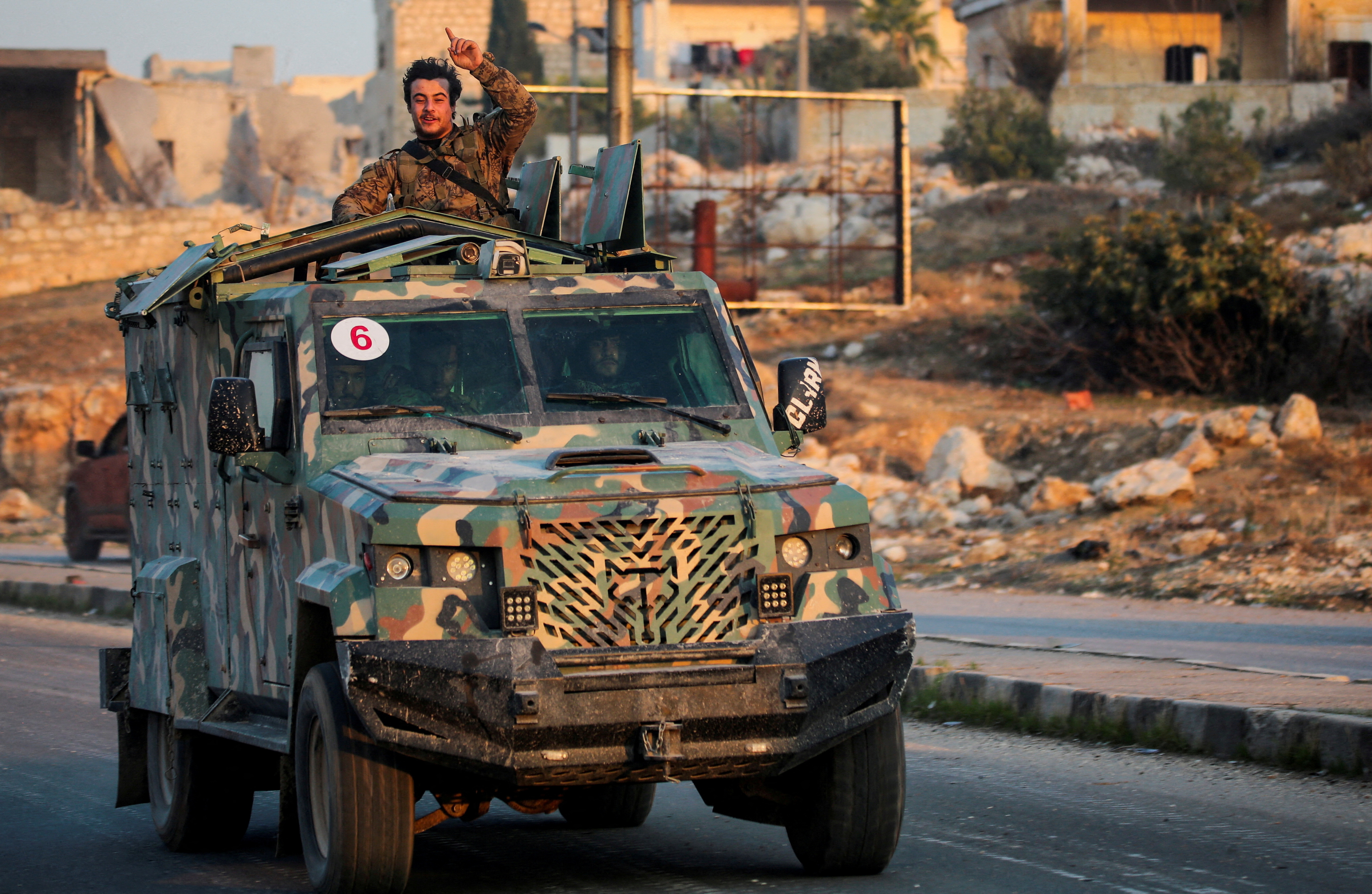 FILE PHOTO: A rebel led by the Islamist militant group Hayat Tahrir al-Sham stands in the back of a vehicle in al-Rashideen