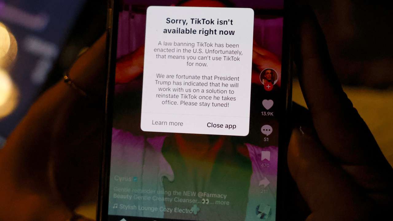 A woman poses with her smartphone displaying the TikTok app afterit stopped working in the United States late on Saturday