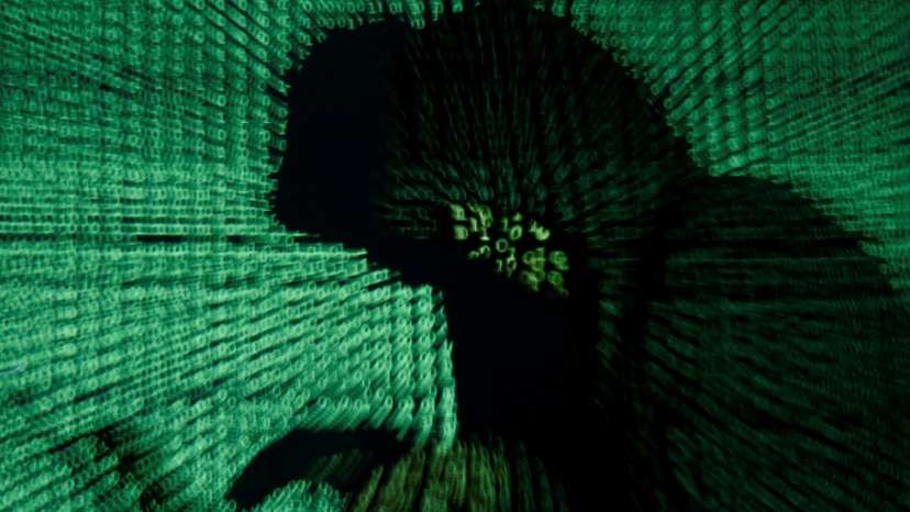 Man holds laptop computer as cyber code is projected on him in this illustration picture