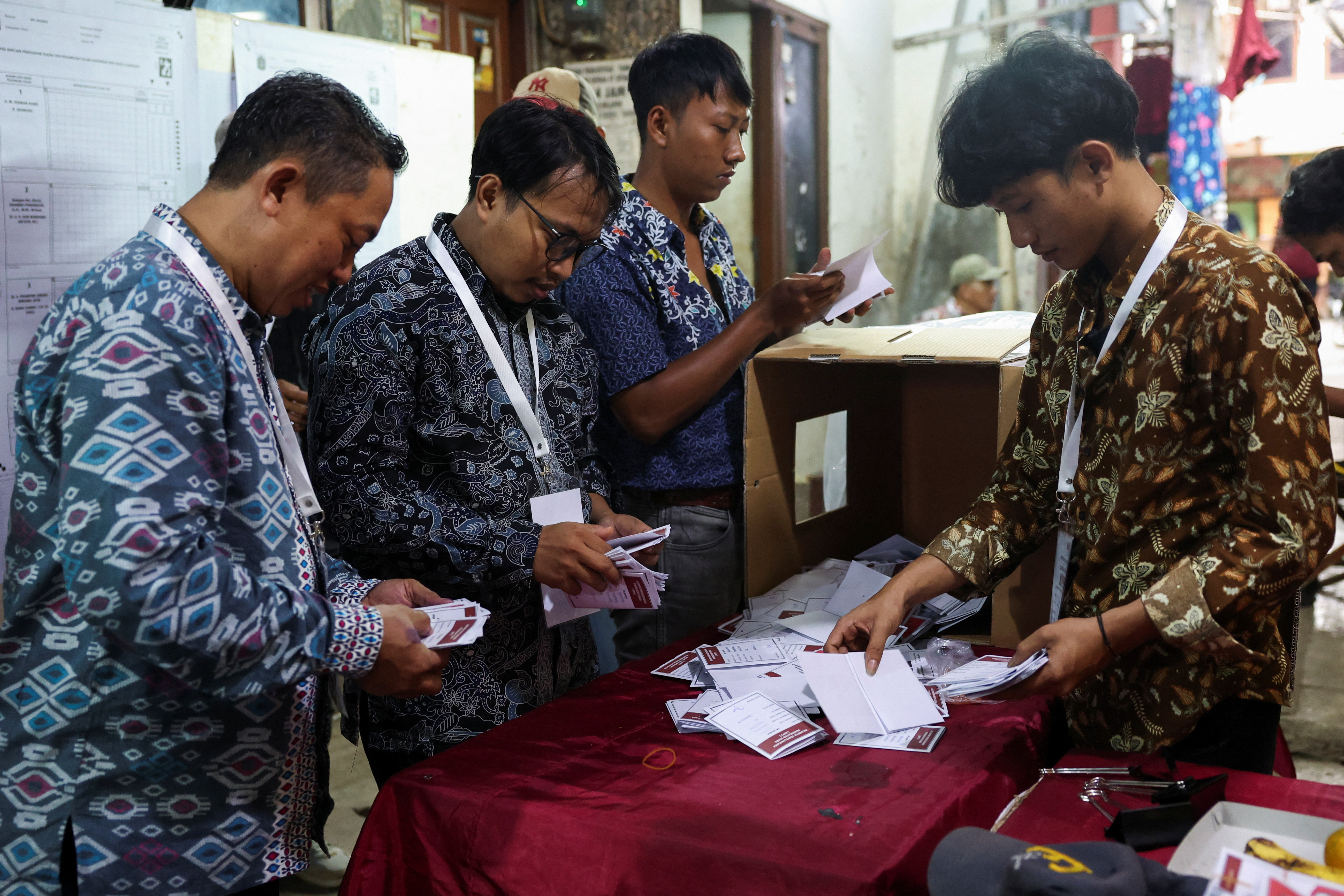 Electoral officers count votes at a polling station after regional elections at a slum area, in Jakarta