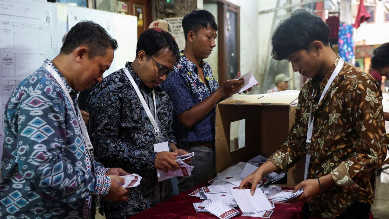 Electoral officers count votes at a polling station after regional elections at a slum area, in Jakarta