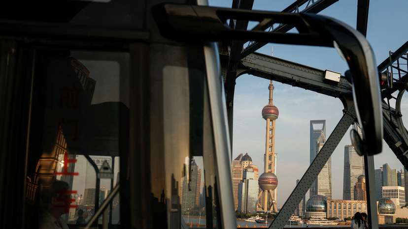 A bus moves past a bridgewith the backdrop of the financial district of Pudong in Shanghai