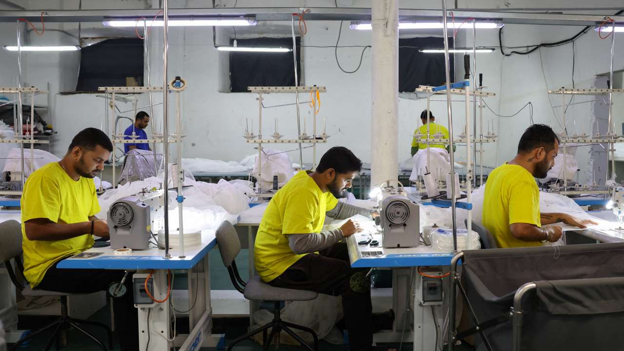 Migrant workers from India sew tulle fabric at a textile factory in Balashikha
