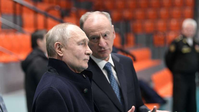 FILE PHOTO: Russian President Vladimir Putin listens to Security Council's Secretary Nikolai Patrushev as they visit a sports hall of the St. Petersburg State Marine Technical University in the city of Saint Petersburg