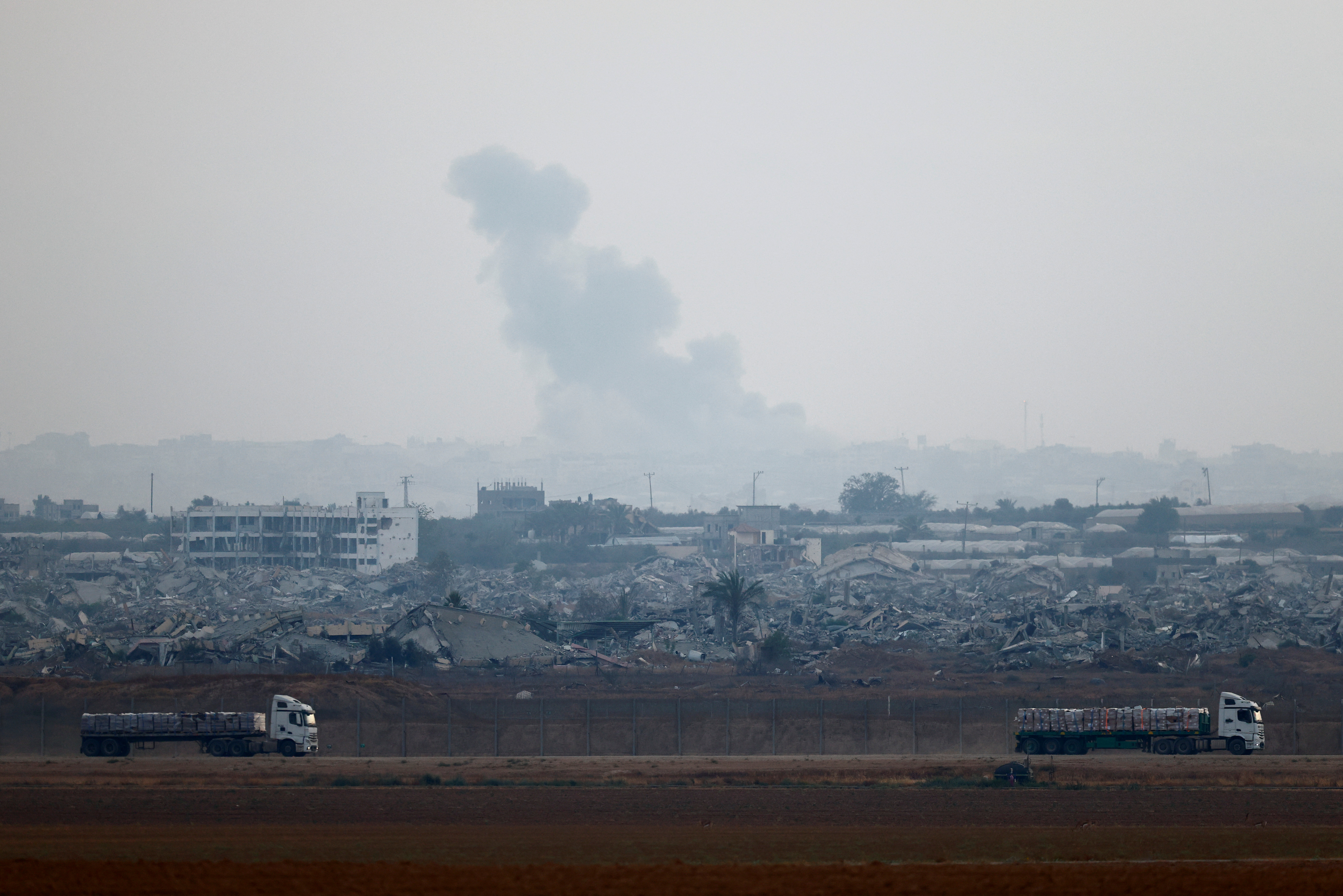 Trucks loaded with aid drive on the Israel-Gaza border as they make their way into Gaza