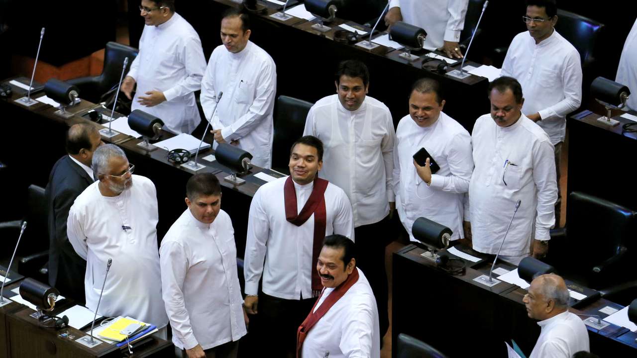 Sri Lanka's newly appointed Prime Minister Rajapaksa and his son Namal look on before they leave the parliament in Colombo