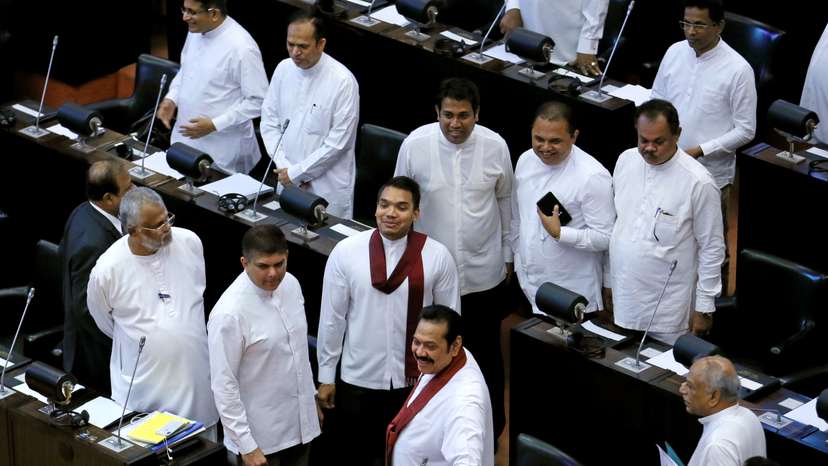 Sri Lanka's newly appointed Prime Minister Rajapaksa and his son Namal look on before they leave the parliament in Colombo