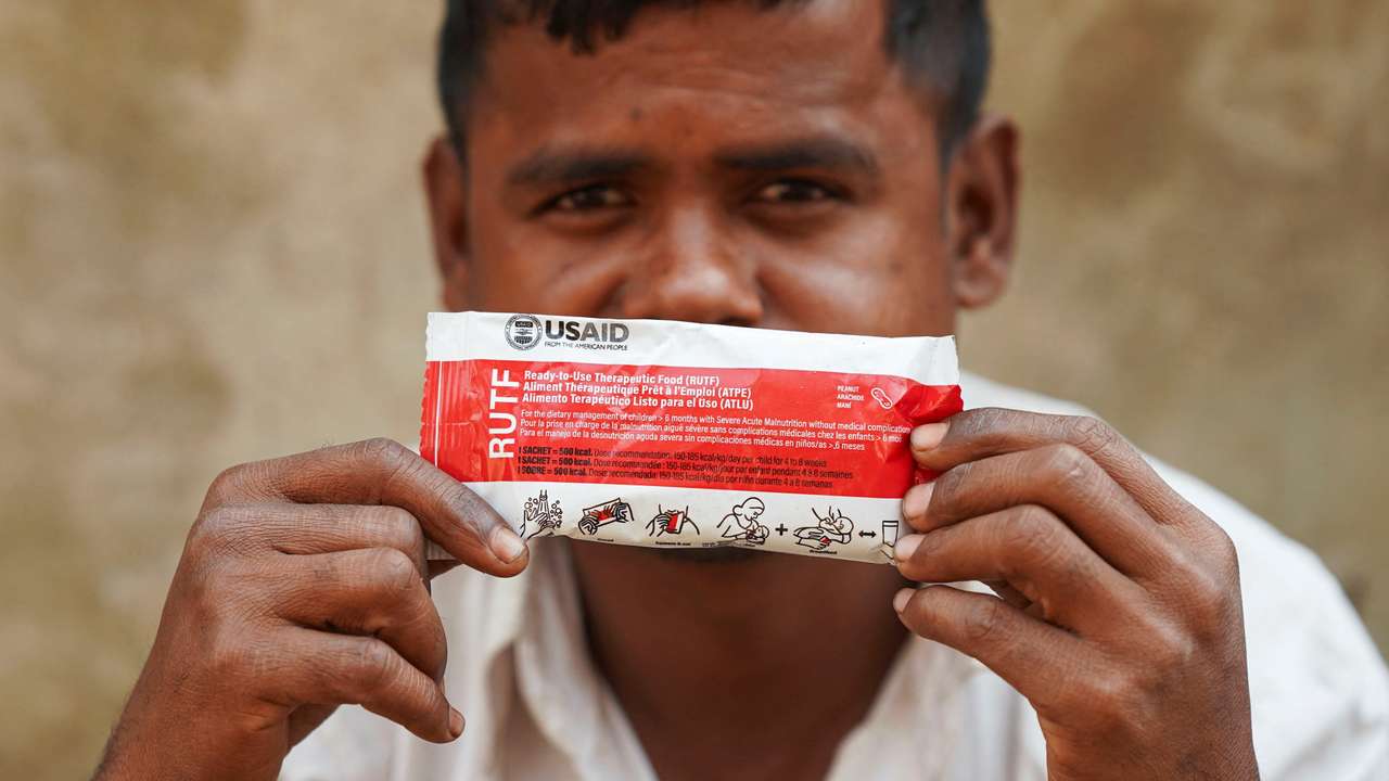 Muhammad Shukkur, 35, a Rohingya man, poses for a picture with a nutrition supplement packet, that has been provided by USAID among Rohingya refugees, in Cox's Bazar