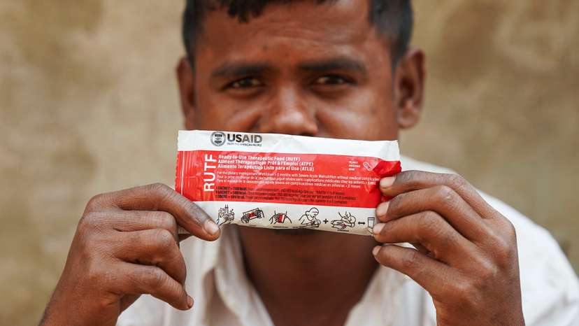 Muhammad Shukkur, 35, a Rohingya man, poses for a picture with a nutrition supplement packet, that has been provided by USAID among Rohingya refugees, in Cox's Bazar