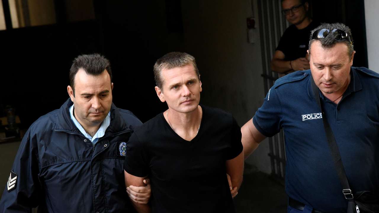 Alexander Vinnik, a 38 year old Russian man suspected of running a money laundering operation using bitcoin, is escorted by police officers while leaving a court in Thessaloniki