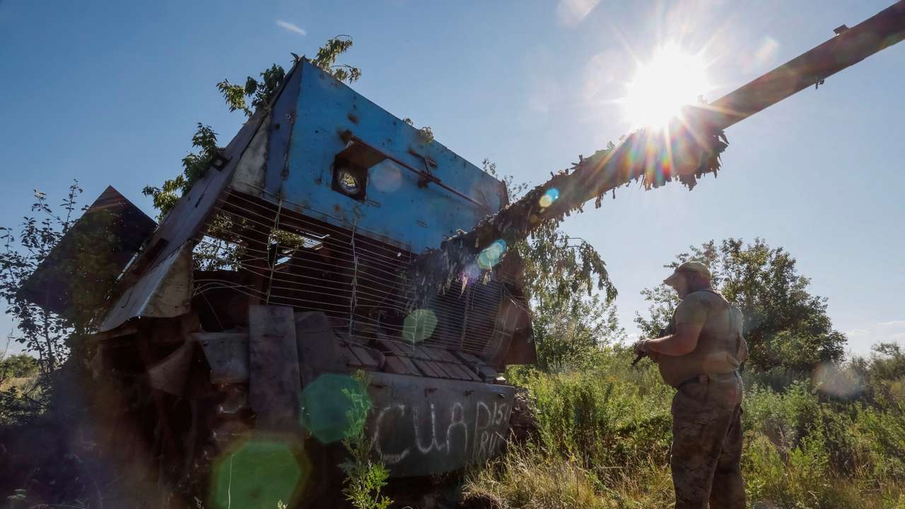 A Ukrainian serviceman appears next to a recently captured Russian T-62 Soviet main battle tank, in Donetsk region