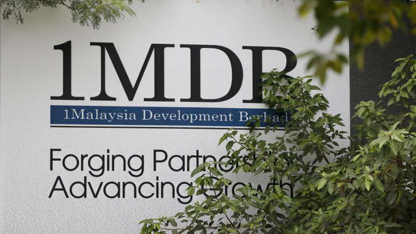 Foliage partly covers a 1 Malaysia Development Berhad (1MDB) billboard at the funds flagship Tun Razak Exchange development in Kuala Lumpur, Malaysia