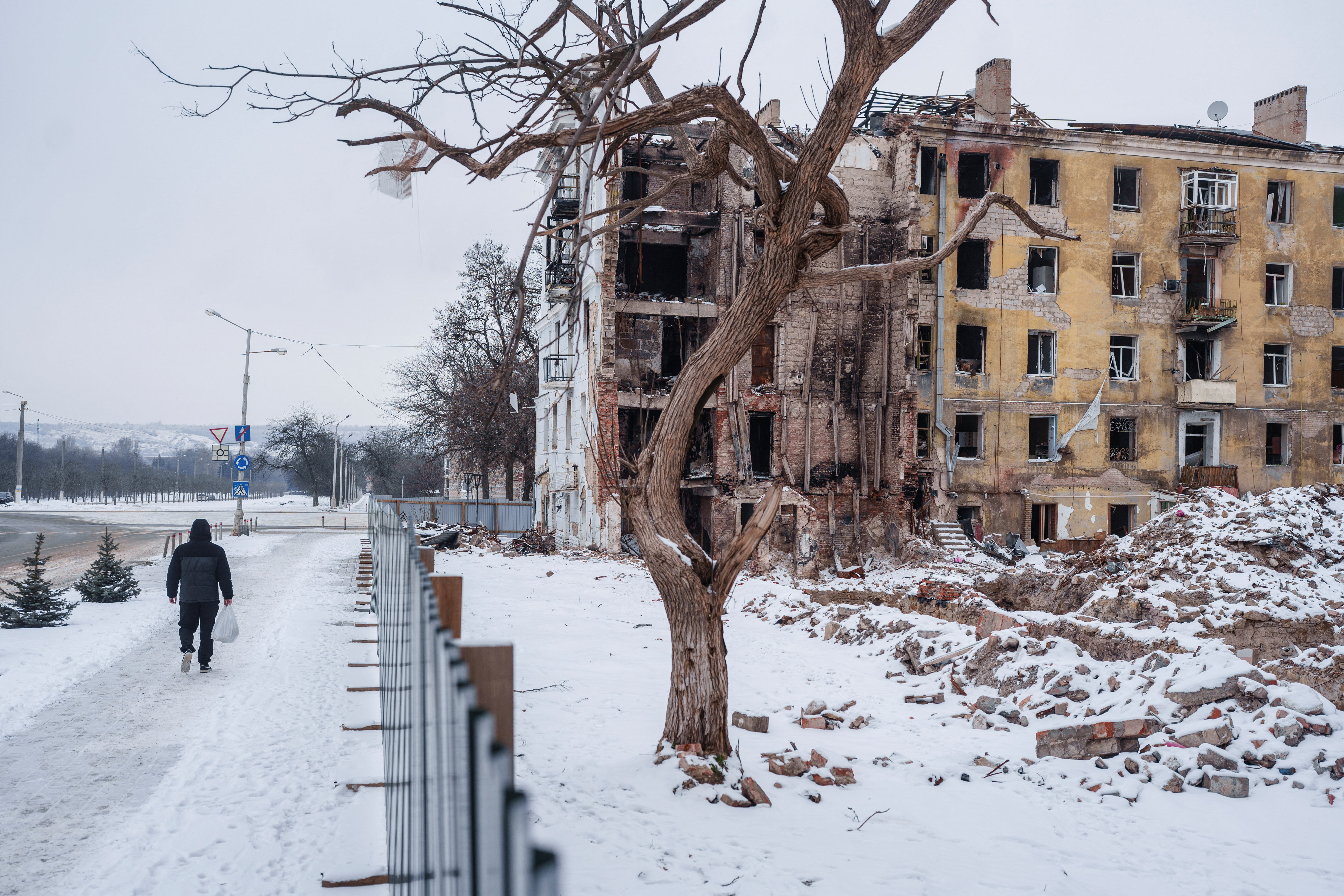 Resident walks next to apartment building hit by a Russian military strike in Kramatorsk, in Kramatorsk