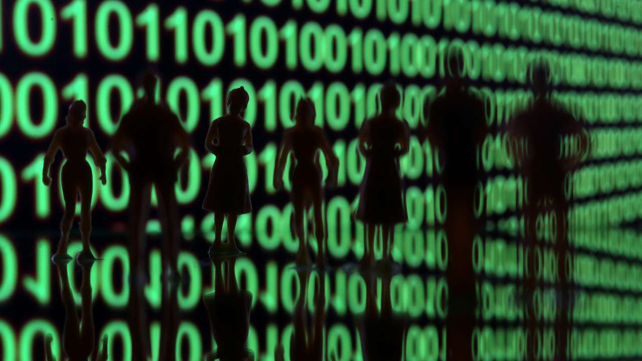 Small toy figures are seen in front of a binary code in this illustration picture