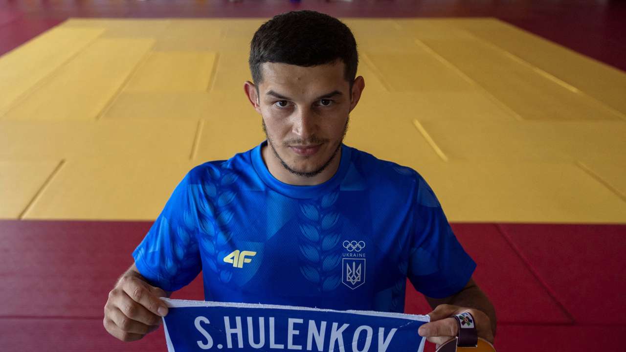 Vadym Chernov, a childhood friend and judo partner of Stanislav Hulenkov, who was killed fighting against Russia's invasion, holds the name tag of his late friend and the medal he dedicated to him at their training base in Kyiv