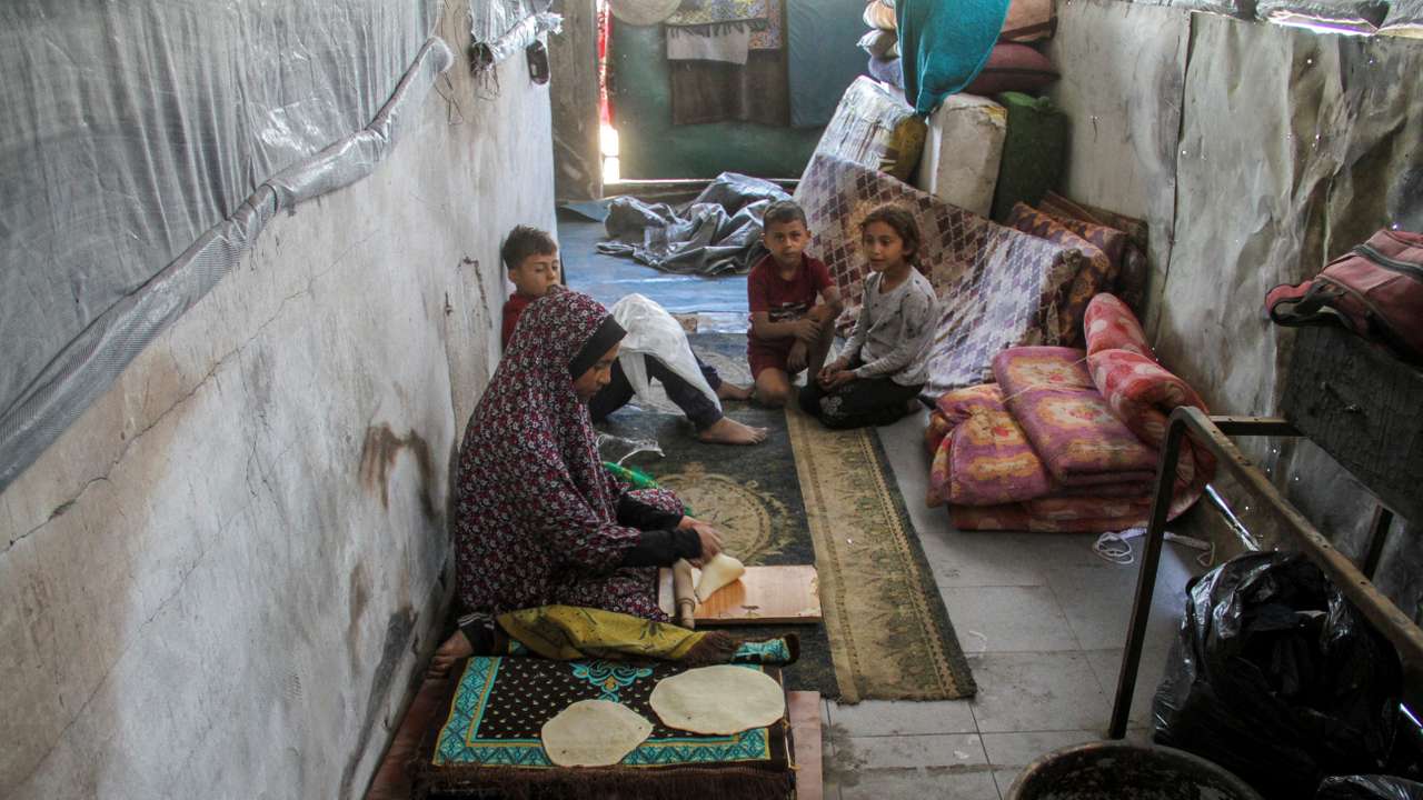 Displaced Palestinian family returns to a damaged school following Israeli raid
