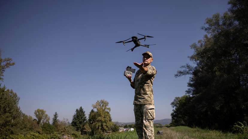 Ukrainian border guard launches a drone he uses to survey the border to Romania in Tyachiv