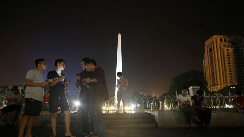 Youths play Pokemon Go in front of City Hall in central Yangon