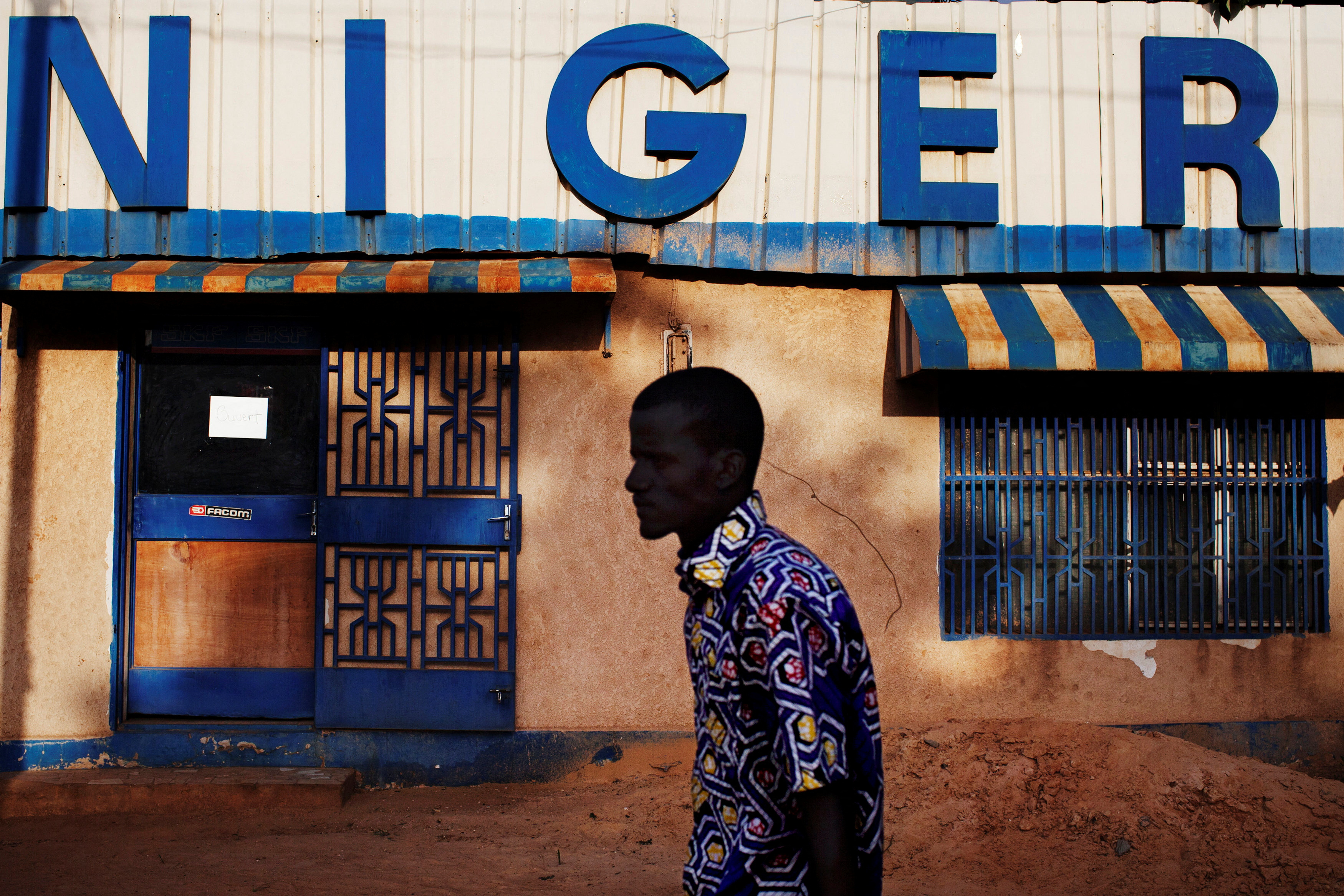 FILE PHOTO: A man walks past a sign reading "Niger" in Niamey