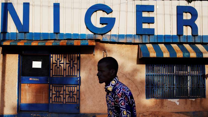 FILE PHOTO: A man walks past a sign reading "Niger" in Niamey