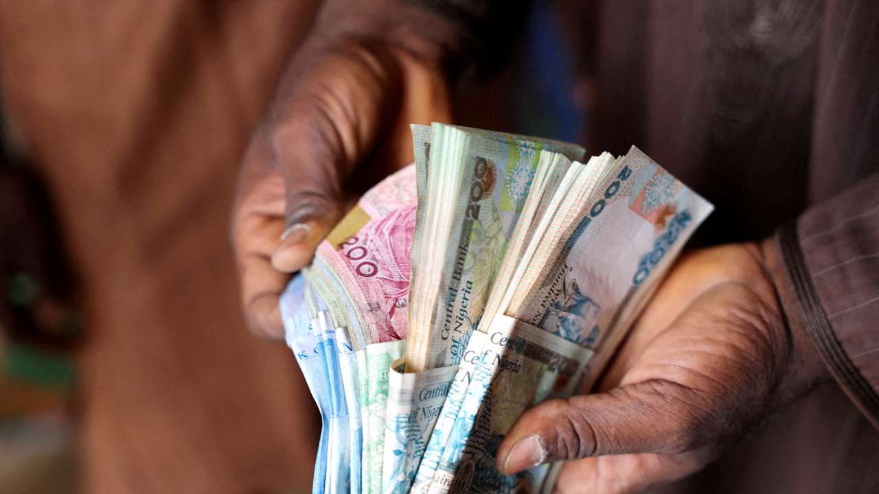 FILE PHOTO: Man counts Nigerian naira notes in a market place in Yola