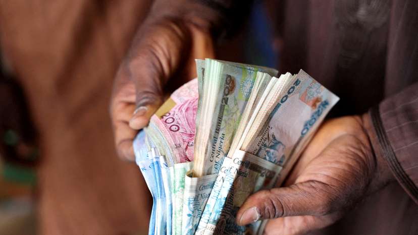 FILE PHOTO: Man counts Nigerian naira notes in a market place in Yola