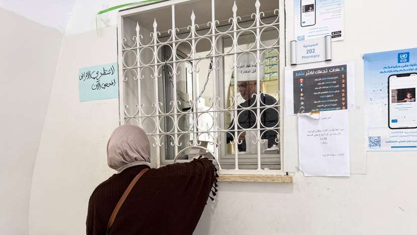 A woman picks up medicine from a pharmacy at a United Nations Relief and Works Agency for Palestine Refugees in the Near East (UNRWA) Jerusalem Center in Jerusalem's Old City