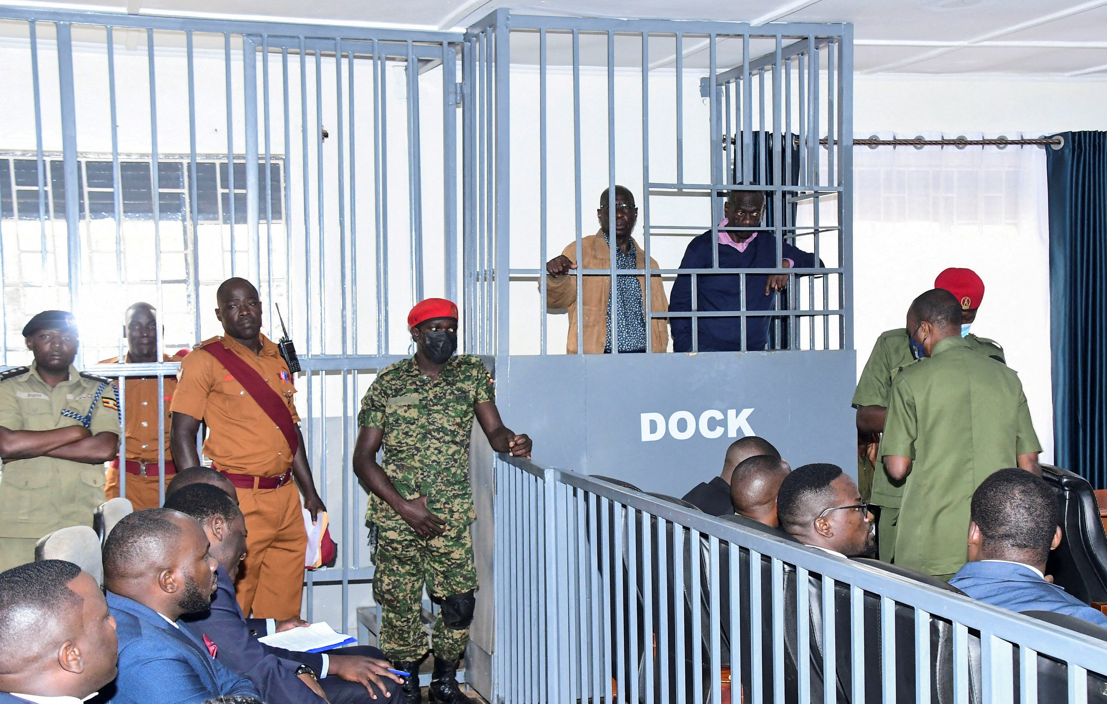 FILE PHOTO: Opposition leader Kizza Besigye and Obeid Lutale stand in a steel dock at the Uganda Military General Court Martial in Makindye, a suburb of Kampala