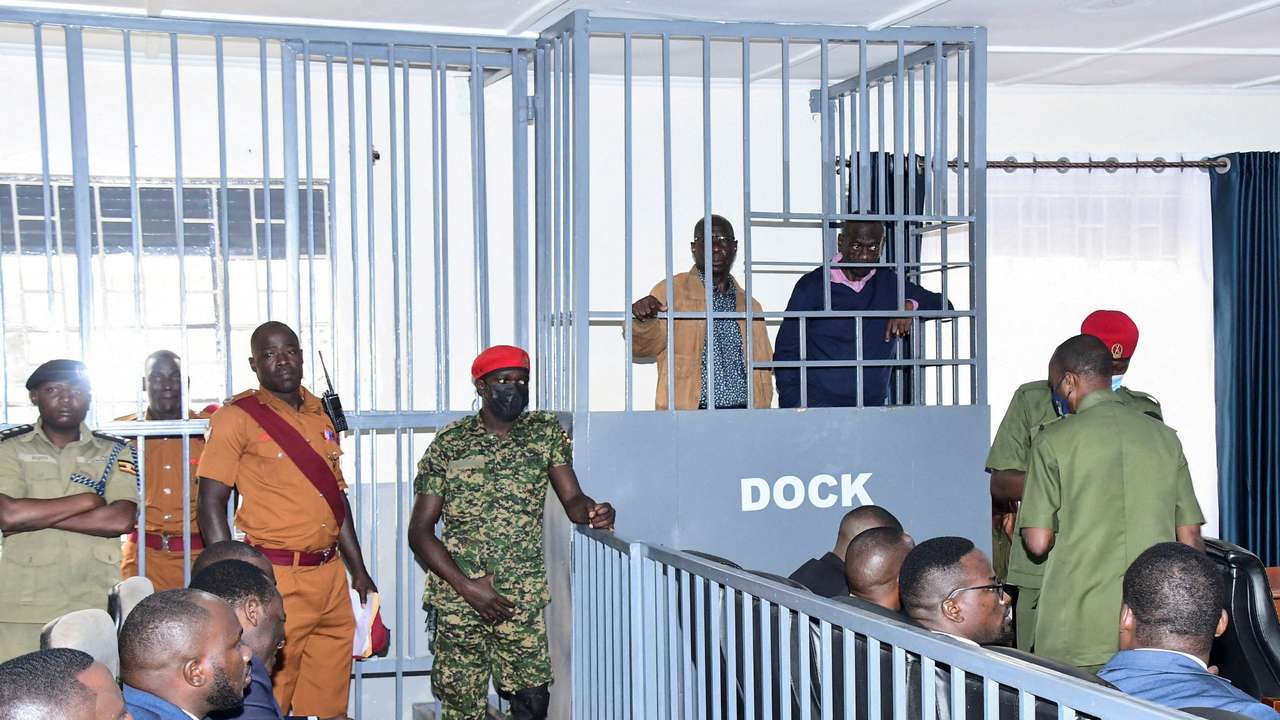 FILE PHOTO: Opposition leader Kizza Besigye and Obeid Lutale stand in a steel dock at the Uganda Military General Court Martial in Makindye, a suburb of Kampala