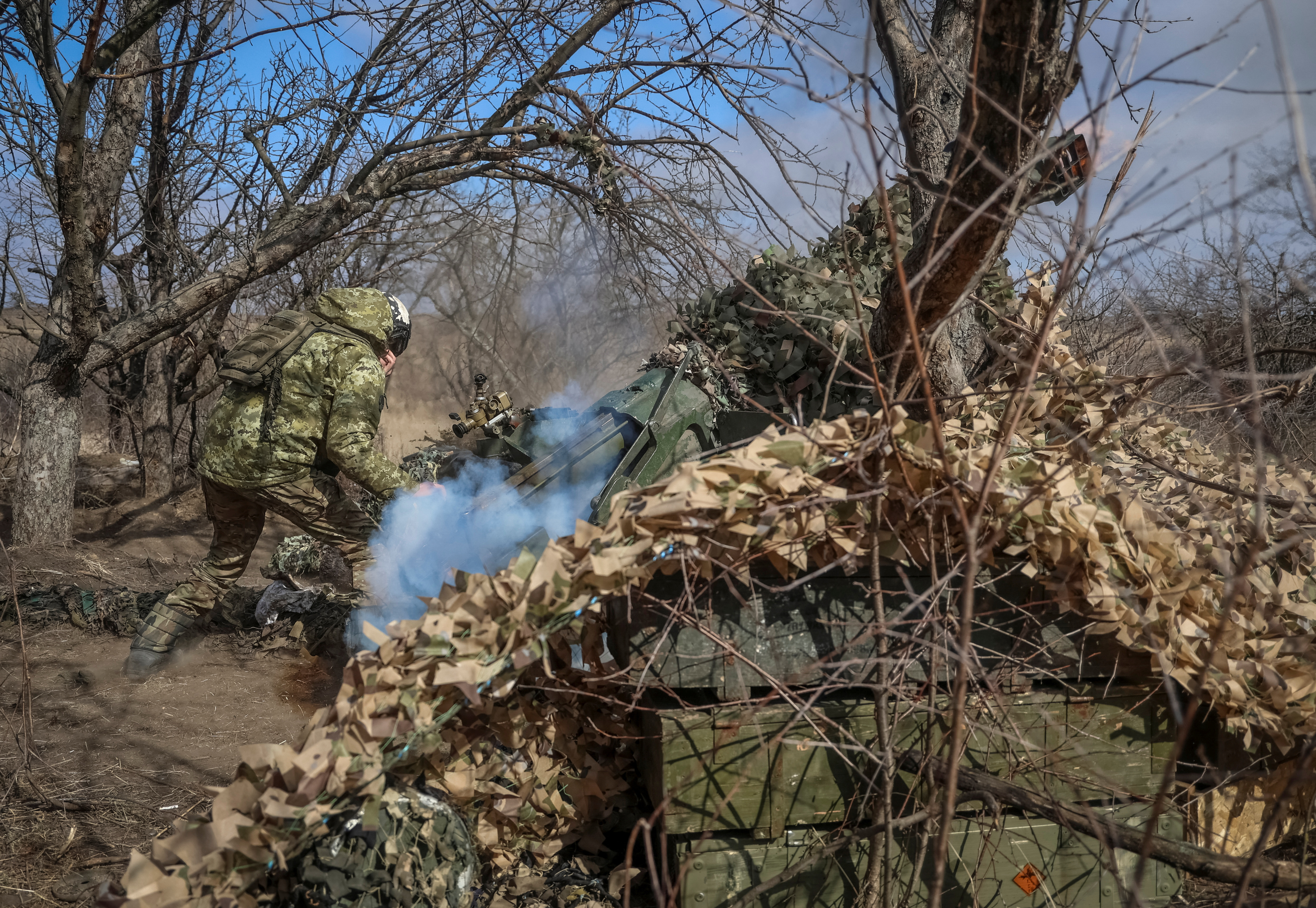Ukrainian service members fire a towed artillery-piece mortar towards Russian troops, amid Russia's attack on Ukraine, near the town of Bakhmut