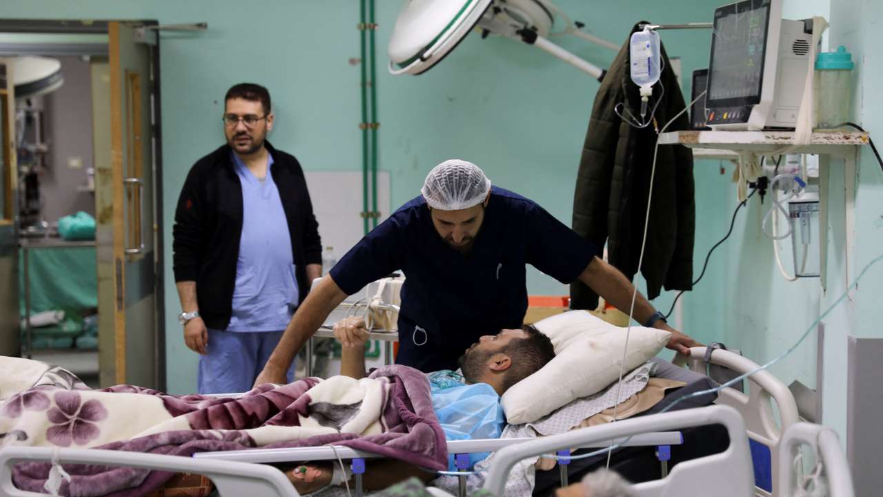 Palestinian-Irish plastic surgeon Ahmed El Mokhallalati checks a Palestinian man wounded in an Israeli strike, at the European Hospital, in Khan Younis in the southern Gaza Strip
