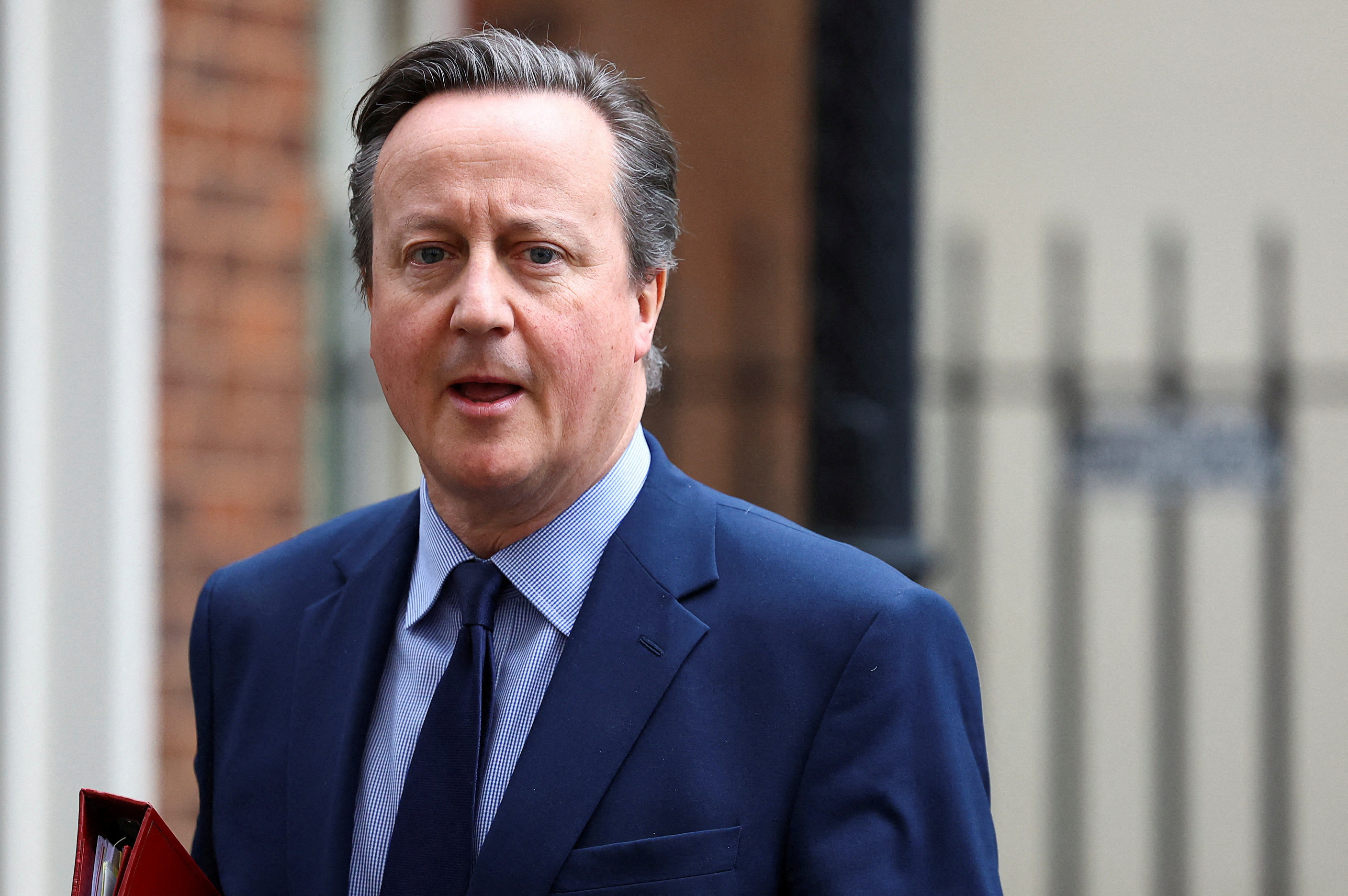 FILE PHOTO: British Foreign Secretary David Cameron walks at Downing Street in London
