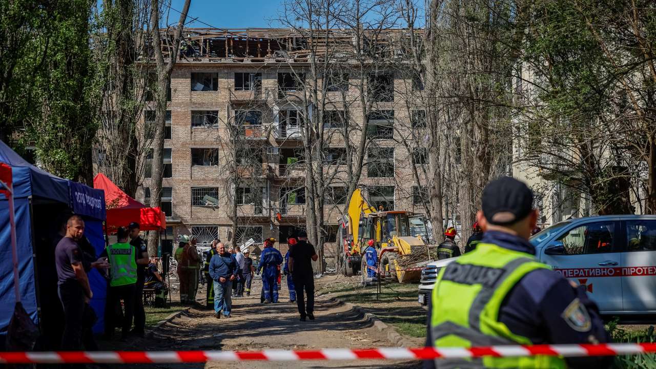 People mourn at the site of a Russian missile strike on a residential area, in Kyiv