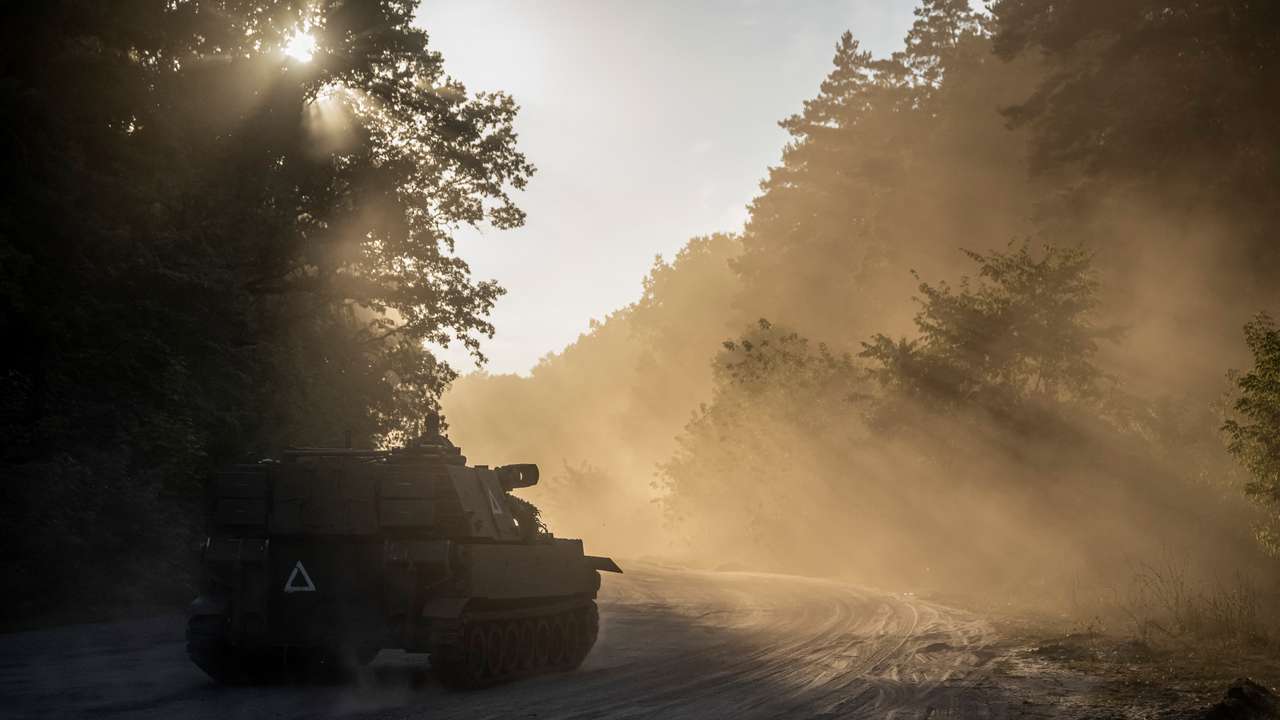 Ukrainian servicemen ride a M109 Paladin self-propelled howitzer near the Russian border in Sumy region
