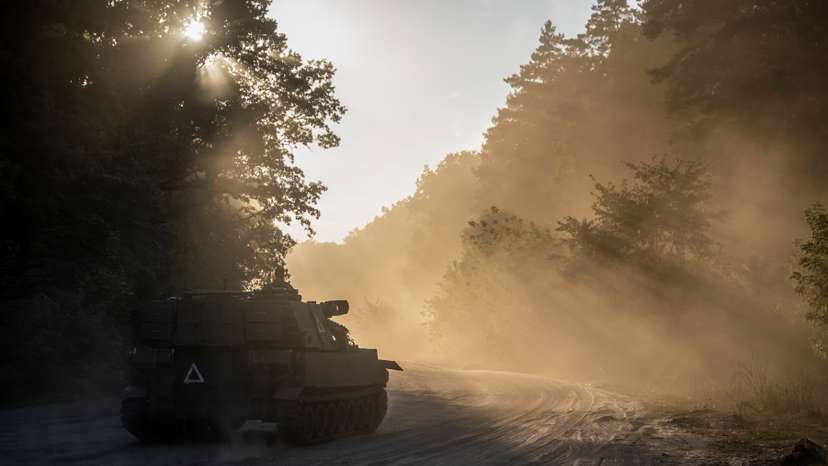 Ukrainian servicemen ride a M109 Paladin self-propelled howitzer near the Russian border in Sumy region