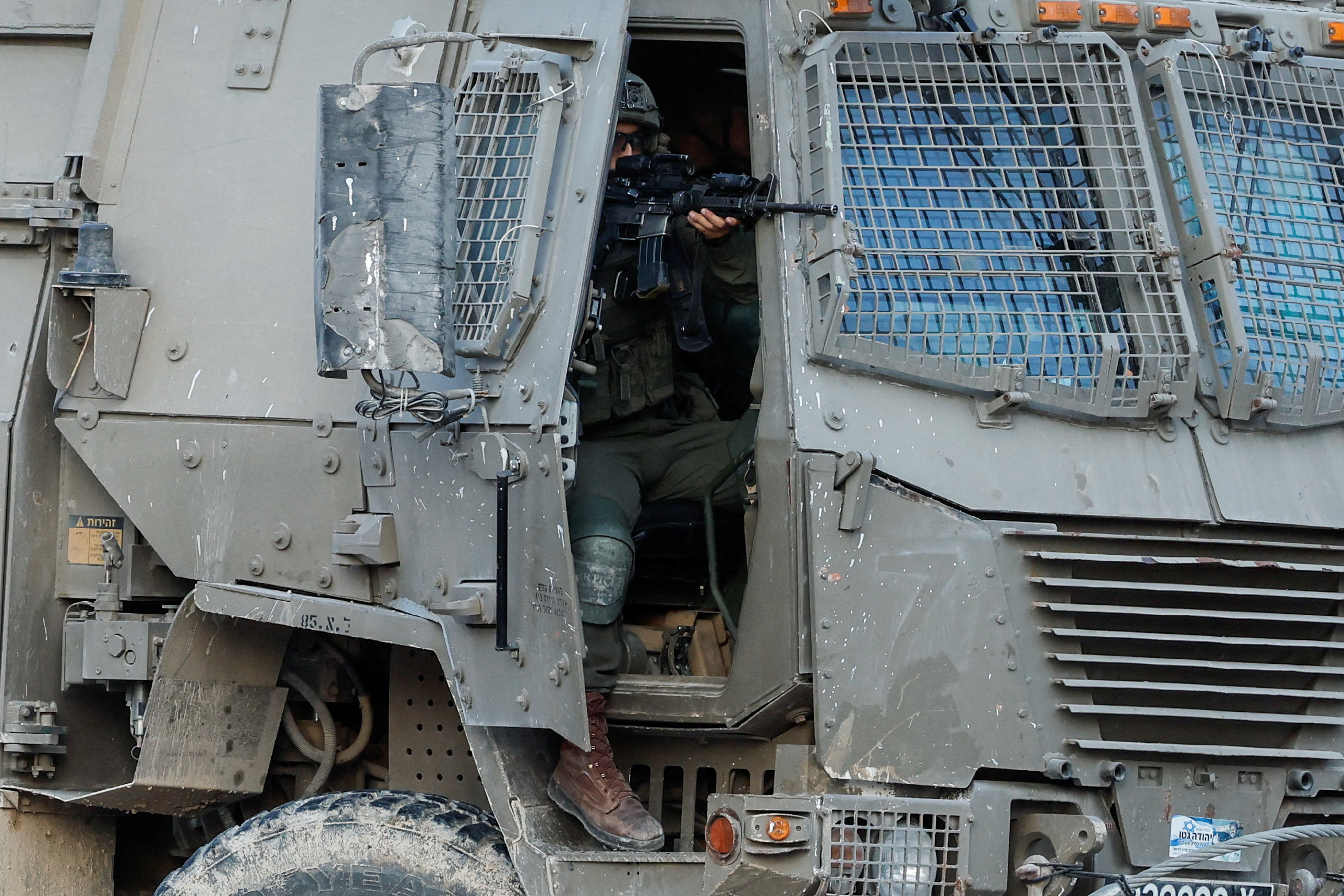 An Israeli soldier holds a weapon in a military vehicle, during an Israeli raid in Tulkarm