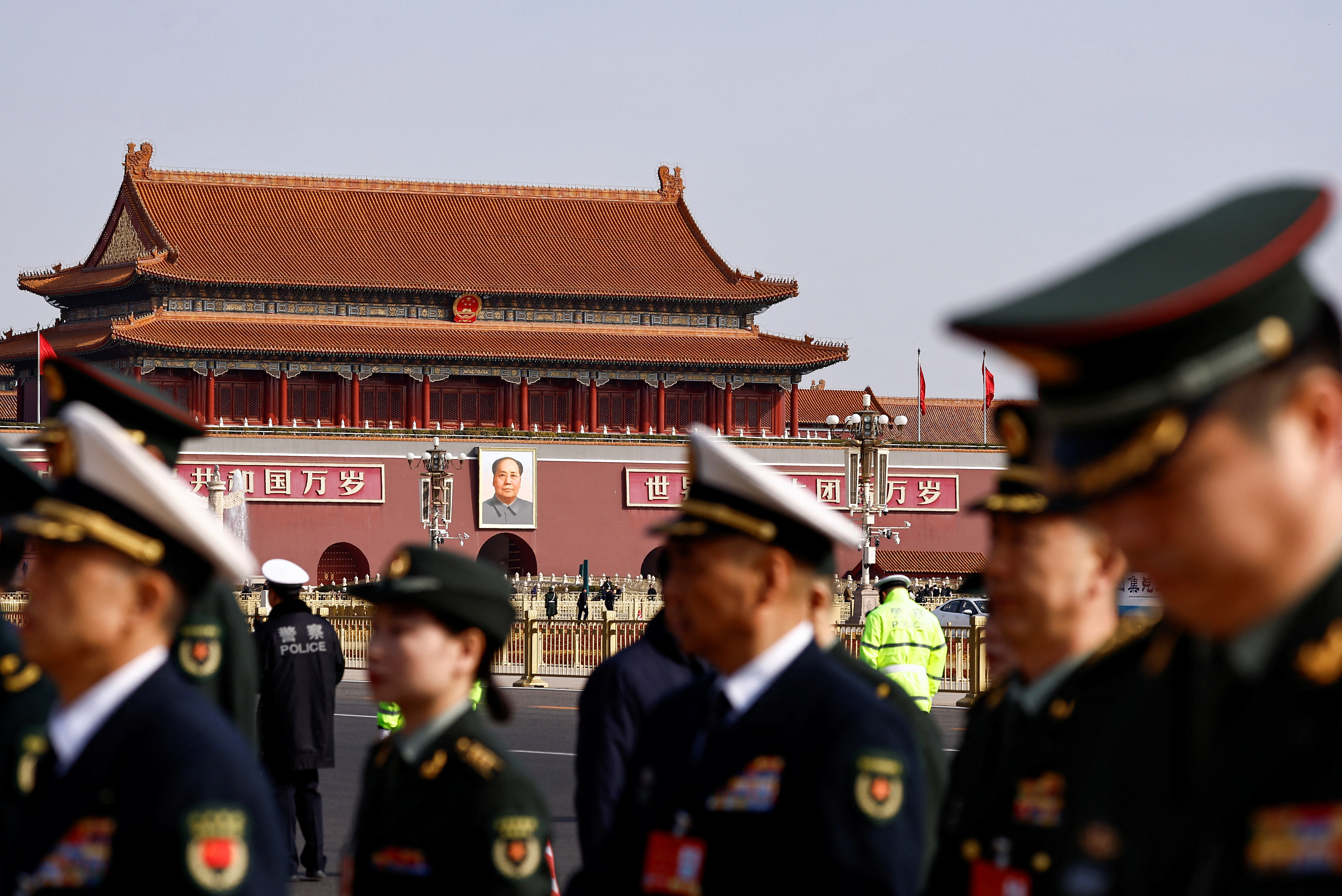 Military delegates walk past Tiananmen Square a day before the National People's Congress (NPC) meeting opens, in Beijing