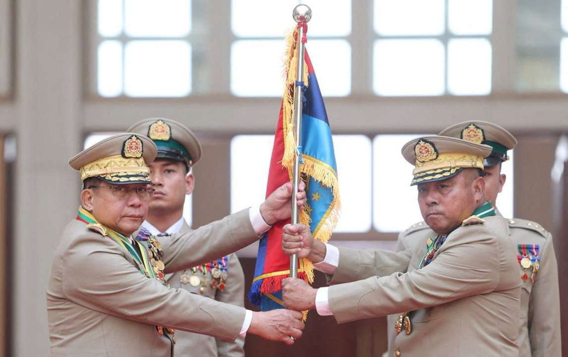 Myanmar junta chief Senior General Min Aung Hlaing hands over a flag to newly appointed Commander-in-Chief General Ye Win Oo during a ceremony in Naypyitaw