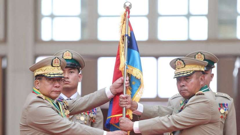 Myanmar junta chief Senior General Min Aung Hlaing hands over a flag to newly appointed Commander-in-Chief General Ye Win Oo during a ceremony in Naypyitaw