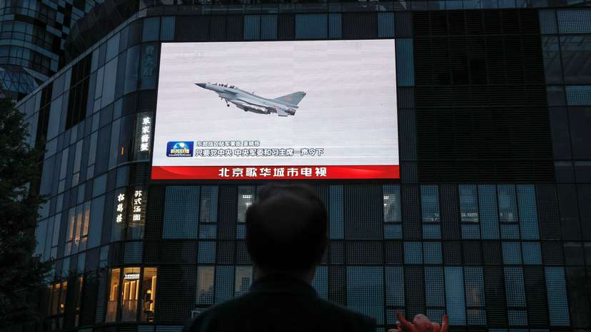 A screen shows news footage of military drills conducted in areas around the island of Taiwan by the Eastern Theatre Command of the PLA in Beijing