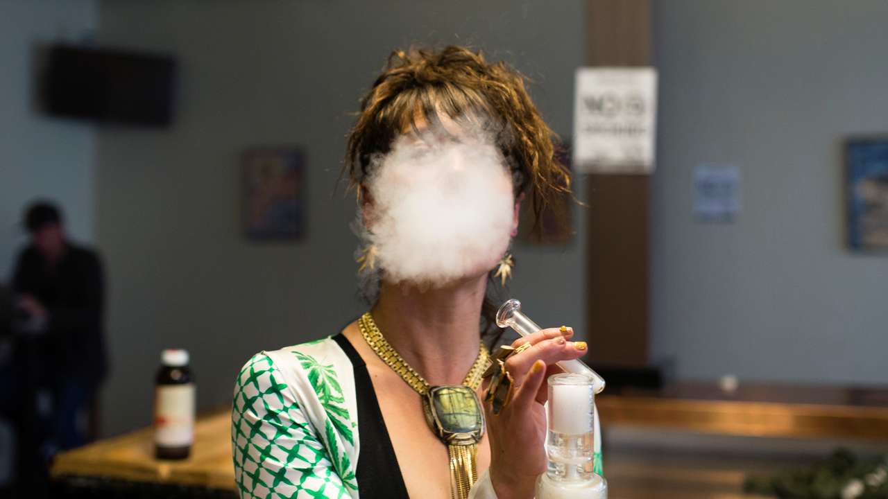 FILE PHOTO: A woman uses a full spectrum oil vaporizer at the Magnolia cannabis vape lounge