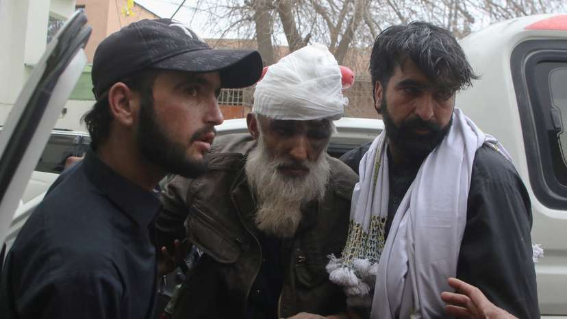 People escort a person who was wounded in a bomb blast on a vehicle carrying coal miners, at a hospital in Quetta